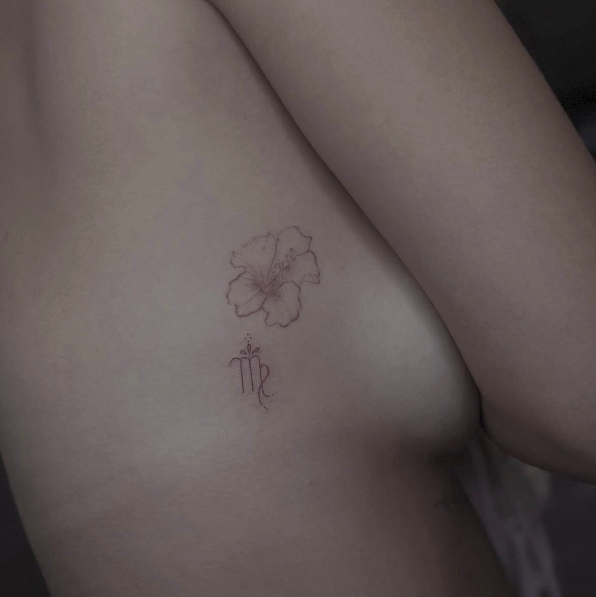 Fine line hibiscus flower and Virgo symbol tattoo on the ribs