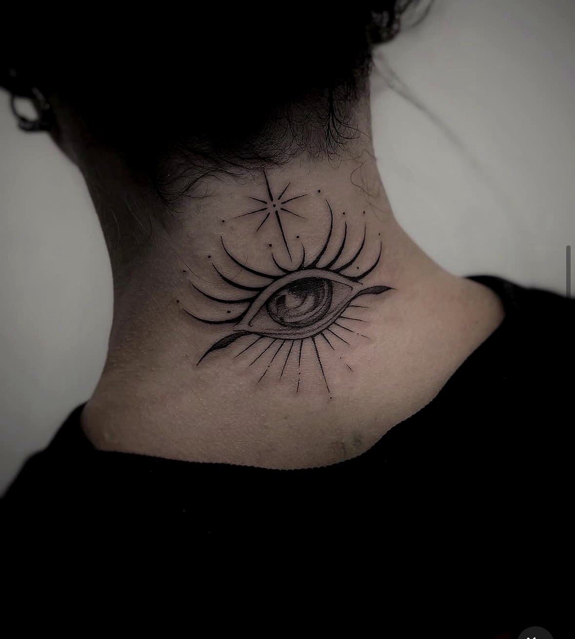 Fine line eye tattoo on the back of the neck